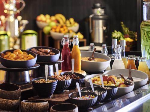 a buffet with bowls of food on a table at Mercure Paris Boulogne in Boulogne-Billancourt