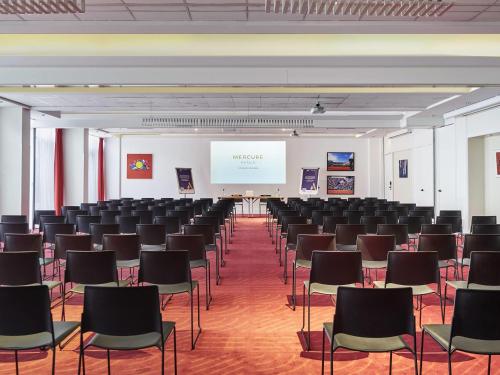 a room with rows of chairs and a white screen at Mercure Paris Boulogne in Boulogne-Billancourt