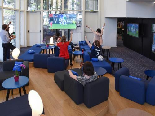 a group of people sitting on blue chairs in a room at Mercure Paris Boulogne in Boulogne-Billancourt
