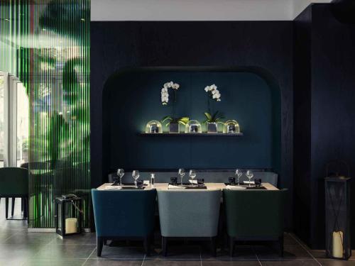 a dining room with a table and blue walls at Mercure Paris Boulogne in Boulogne-Billancourt