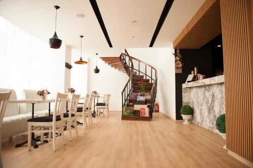 a dining room with a table and chairs and a staircase at Aqvatonic Hotel - Steaua de Mare in Eforie Nord