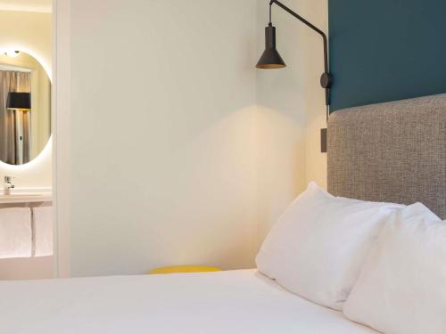 a bedroom with a white bed and a mirror at ibis Marseille Centre Euromed in Marseille