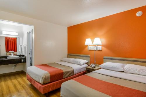 a hotel room with two beds and a sink at Motel 6-Schiller Park, IL - Chicago O'Hare in Rosemont