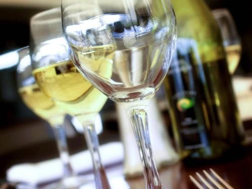 two glasses of white wine sitting on a table at Mercure Bunbury Sanctuary Golf Resort in Bunbury