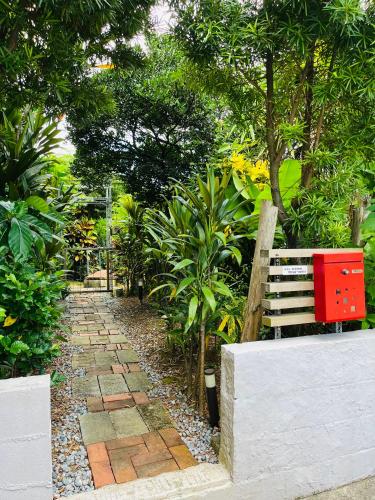 a path in a garden with a bench and trees at 香琉 Kaoru in Miyako Island