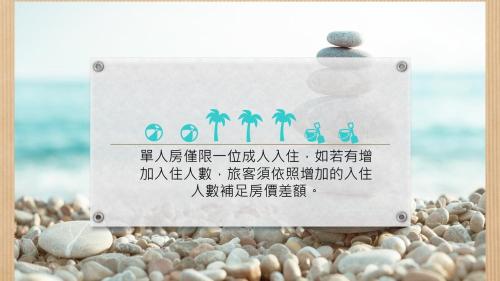 a sign on a rocky beach with writing on it at TK Happiness 168 B&B in Donggang
