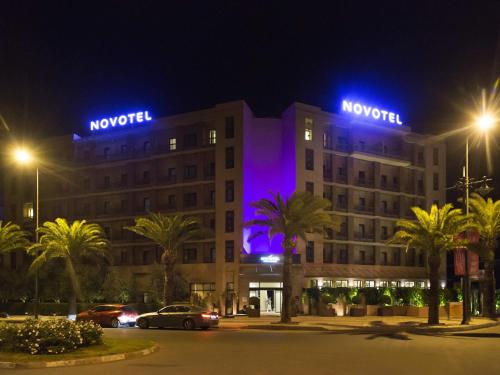 a hotel with blue lights on top of it at night at Novotel Marrakech Hivernage in Marrakech