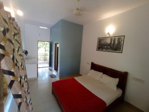 a bedroom with a bed with a red blanket at Monte Sereno Munnar in Anachal