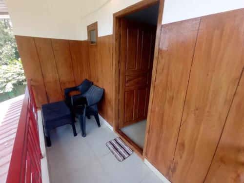 a small room with two chairs and a door at Monte Sereno Munnar in Anachal