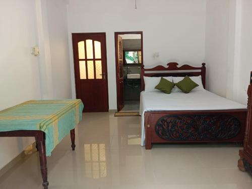 a bedroom with two beds and a door with a door at Cinnamon Villa Ambalangoda in Ambalangoda