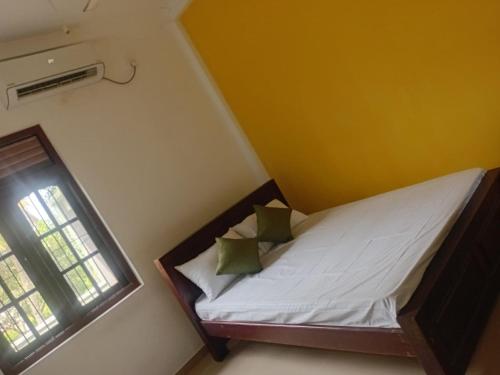 a small bed in a room with a window at Cinnamon Villa Ambalangoda in Ambalangoda
