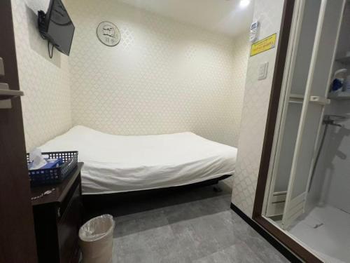 a small room with a bed and a mirror at 依茶宿 in Matsudo