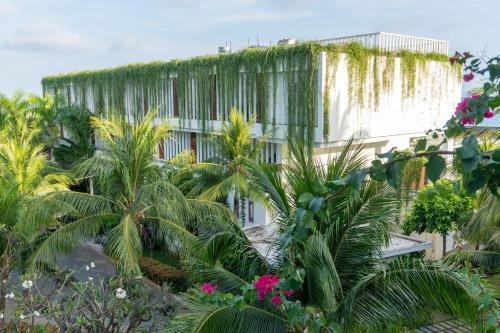a building with a lot of plants in front of it at The Cliff Resort & Residences in Mui Ne