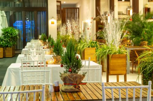 a room filled with tables and chairs with plants at The Cliff Resort & Residences in Mui Ne