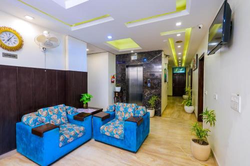 a lobby with two blue chairs and a tv at Nikko Blue - Boutique Hotel in Gurgaon