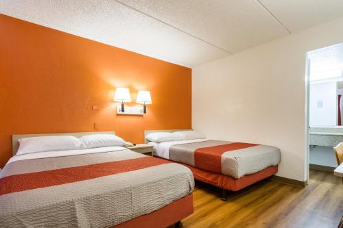 two beds in a room with orange walls at Motel 6 Tempe, AZ Phoenix Airport Priest Dr in Tempe