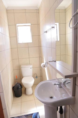a small bathroom with a toilet and a sink at Best Enough Guesthouse in Pretoria