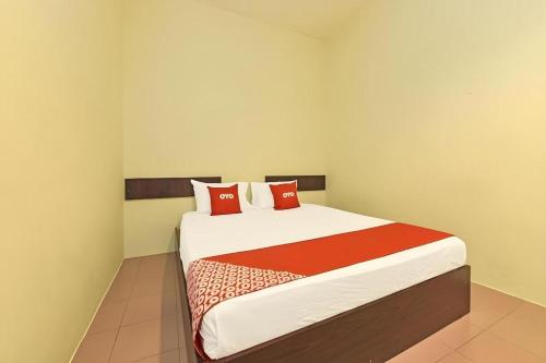 a bedroom with a large bed with red pillows at SPOT ON 91178 Motel Impian in Seri Manjung