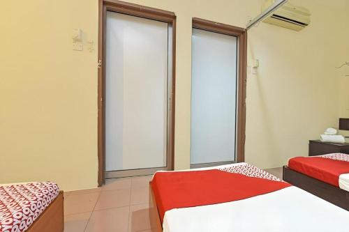 a bedroom with two beds and two large windows at SPOT ON 91178 Motel Impian in Seri Manjung