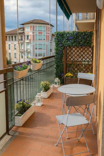 a patio with a table and chairs on a balcony at Beautiful floral apartment on Navigli in Milan