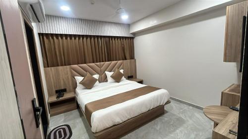 a bedroom with a large bed in a room at Hotel Noble Town in Gandhinagar