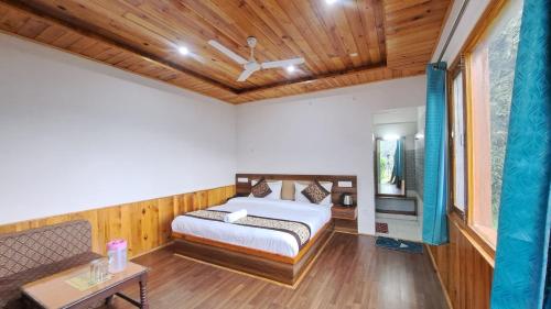 a bedroom with a bed and a wooden ceiling at Paradise Village Resort in Shimla
