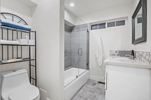 ein weißes Badezimmer mit einer Badewanne, einem WC und einem Waschbecken in der Unterkunft Forest Retreat with Decks, Game Room & Walk to Lake in Lake Arrowhead