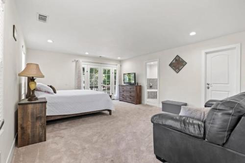 ein Schlafzimmer mit einem Bett und einer Couch in der Unterkunft Forest Retreat with Decks, Game Room & Walk to Lake in Lake Arrowhead