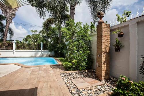 a swimming pool in a backyard with a fence and palm trees at First Ao Nang Private Pool Villa in Ao Nang Beach