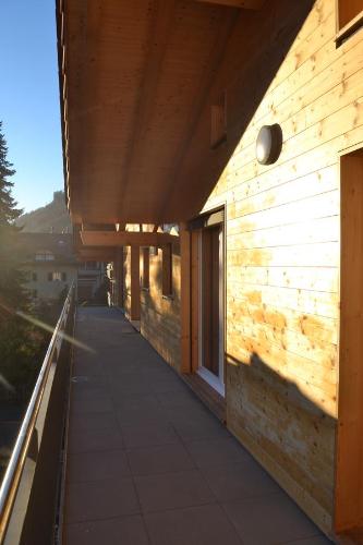 a wooden building with a walkway on the side of it at Swiss Chalet Holidays Ringgenberg in Ringgenberg