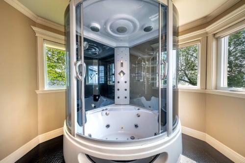 a glass shower in a room with two windows at Incredible view - Chateau au bord du fleuve in Saint-Augustin-de-Desmaures