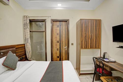 a bedroom with a bed and a desk and a television at Hotel The Anvi Residency in Noida