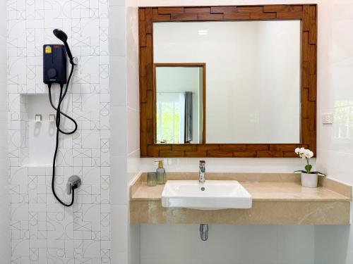 a bathroom with a sink and a mirror at Uncle J House in Phuket