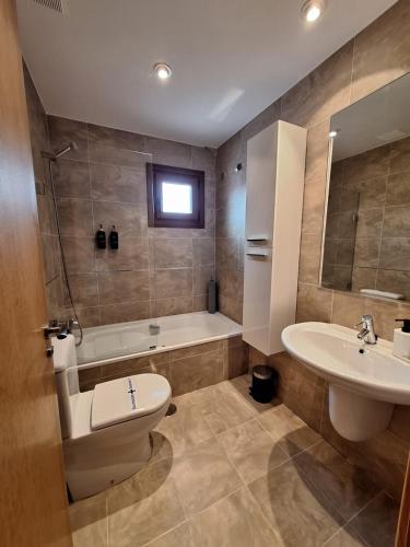 a bathroom with a toilet and a sink and a tub at Aldea Bricia 20 BC in Posada de Llanes