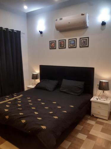 a bedroom with a bed and a air conditioner on the wall at Guests House in Karachi