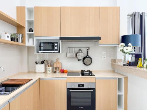 a kitchen with wooden cabinets and a stove top oven at Uncle J House in Phuket