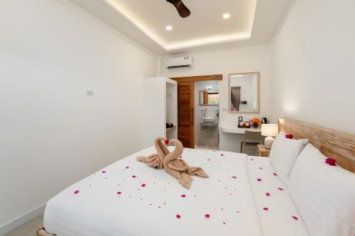 a bedroom with a white bed with a knot at Eden Extend Fisherman's village in Koh Samui 