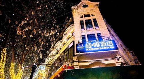 a building with a blue sign on the side of it at James Joyce Coffetel Harbin Central Street in Harbin