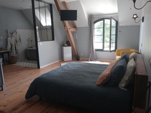 a bedroom with a bed and a large window at Domaine du bois Chaumet in Couzon