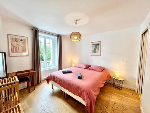 a bedroom with a large bed with red sheets at Jolie maison de familial au cœur de Carantec - TY LAOUEN in Carantec