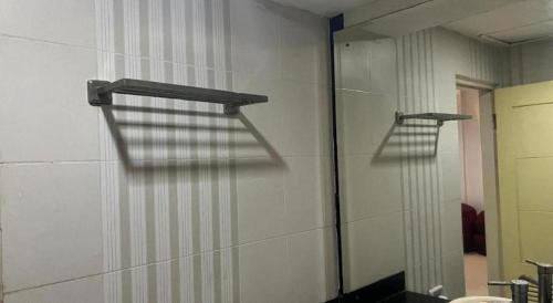 a mirror on the wall of a bathroom at Hotel O Tri Homestay in Palangkaraya