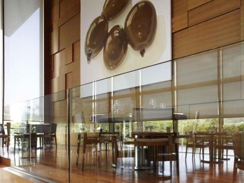 a dining room with tables and chairs and a clock at Novotel Citygate Hong Kong in Hong Kong