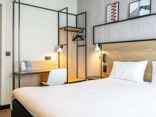 a hotel room with a large bed and a chair at ibis Paris Boulogne Billancourt in Boulogne-Billancourt