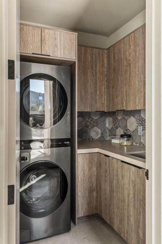 a kitchen with a stainless steel washer and dryer at Suncrest by Fieldtrip - JT Modern w Pool and Views in Joshua Tree