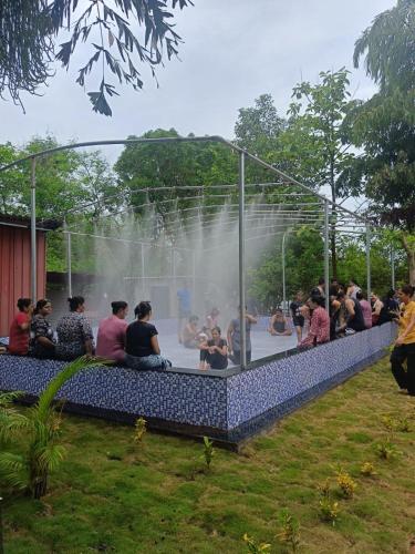 a group of people sitting around a water fountain at Mars Agro Farm - Shahapur in Shāhāpur