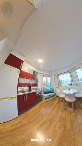 a kitchen and dining room with red cabinets and a table at Port 3 in Tarragona