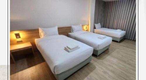 a hotel room with two beds and a chair at Mark Four Place Hotel in Phrae