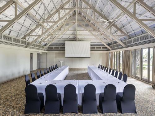 a conference room with a white table and chairs at Novotel Nadi in Nadi