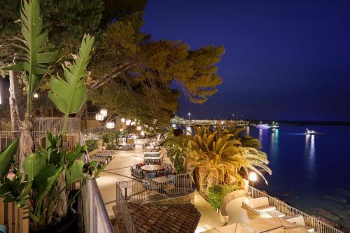 a view of a patio with a view of the water at night at Le Calette N.5 in Cefalù