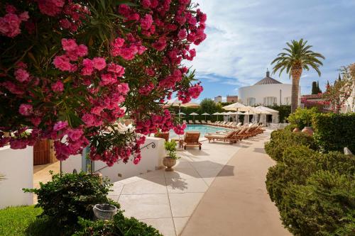 a garden with pink flowers and a swimming pool at Le Calette N.5 in Cefalù